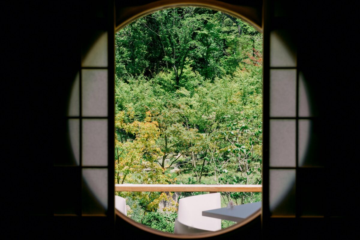 Raam in Japanse stijl met uitzicht op tuin.